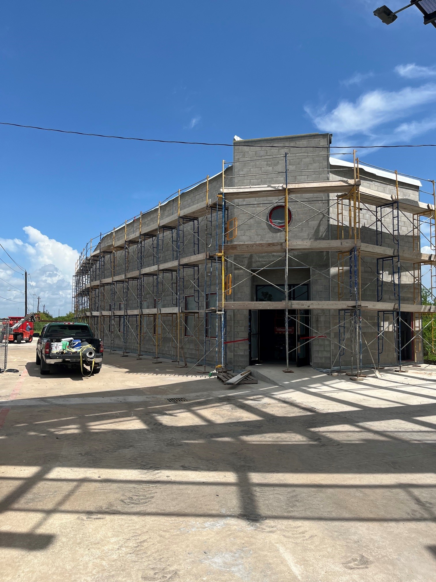 Retail center at the start of construction, bare CMU block with scaffolding